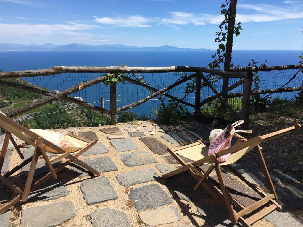 弗洛里Il Nido Del Falco - Art house with terrace and sea view的石头庭院的椅子,俯瞰着大海