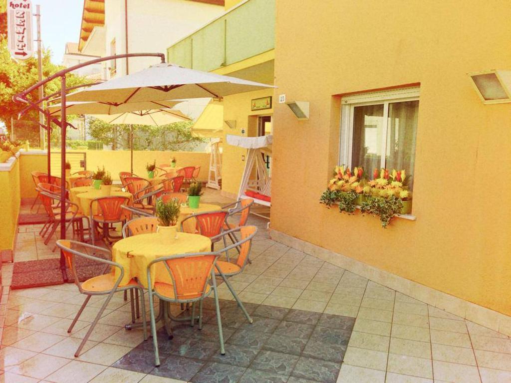 里乔内泽尼特酒店的一个带桌椅和遮阳伞的户外庭院