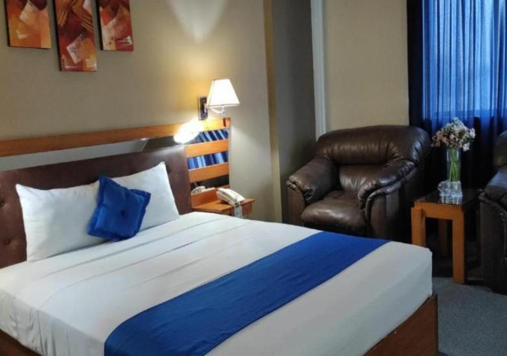利马蓝星酒店的卧室配有蓝色和白色的床和椅子