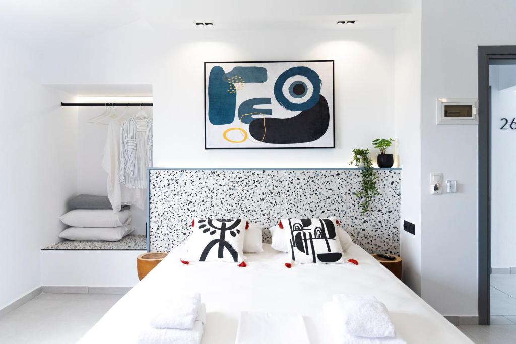 卡沃斯Seaside Suites的卧室配有白色的床和黑白色枕头