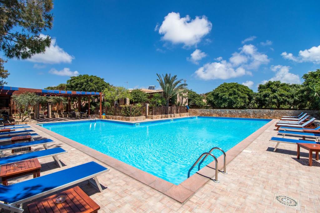 兰佩杜萨Residence Villalba的一个带蓝色躺椅的游泳池,一个度假胜地
