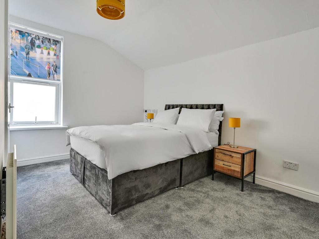 曼彻斯特Albert View Rooms的白色的卧室设有一张大床和一个窗户