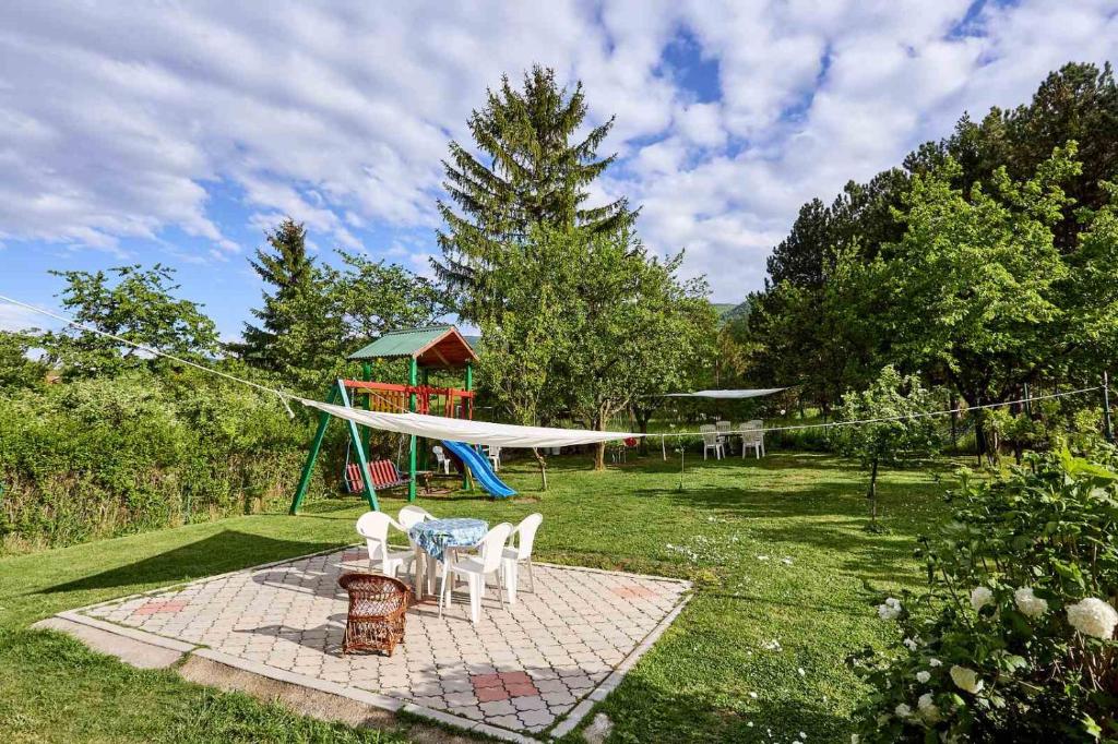 索科矿泉村Apartmani Stanojevic Sokobanja的后院设有野餐桌和游乐场