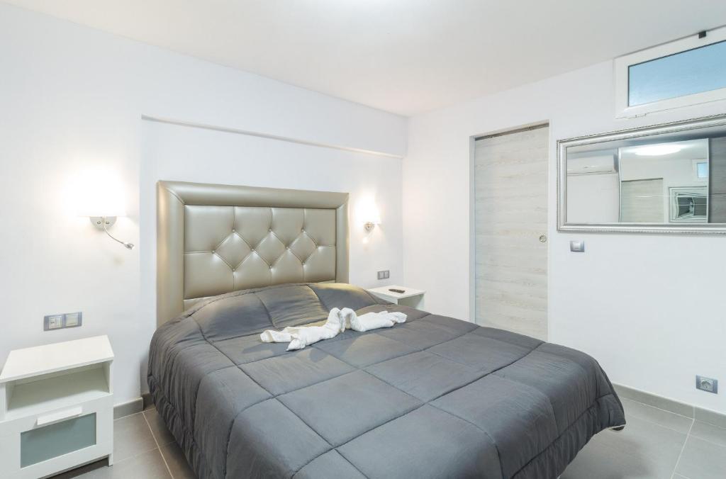 圣巴托洛梅Holiday Home Alexia Oceanfront的一间卧室配有一张大床,上面有两只白色动物