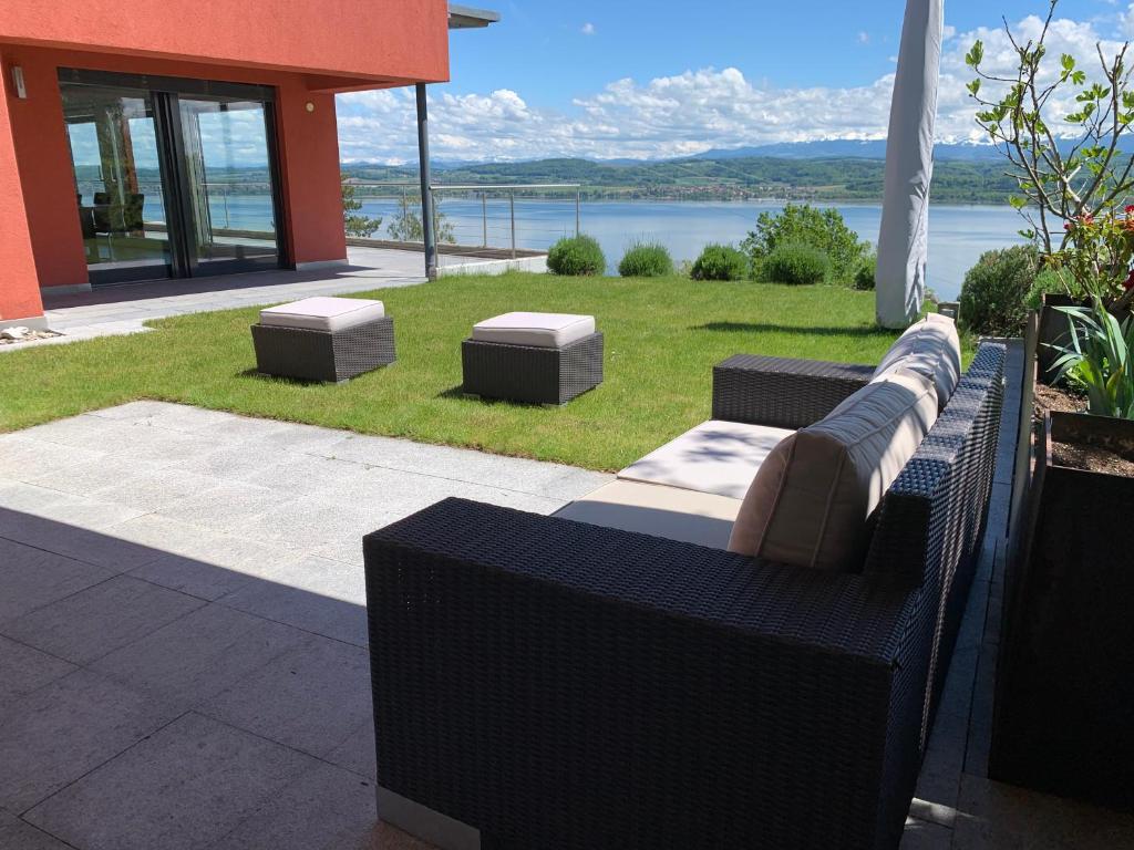 BelleriveVilla au bord du lac de Morat avec vue imprenable的天井上的沙发,享有水景