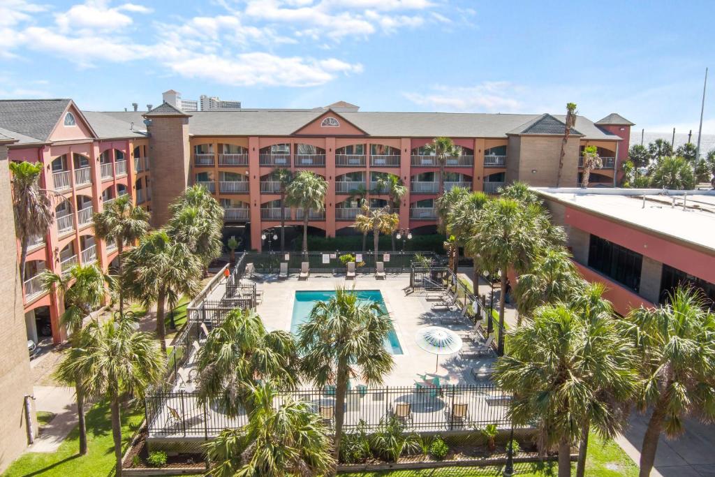 加尔维斯敦Beachfront Palms Hotel Galveston的享有酒店空中景色,设有游泳池和棕榈树