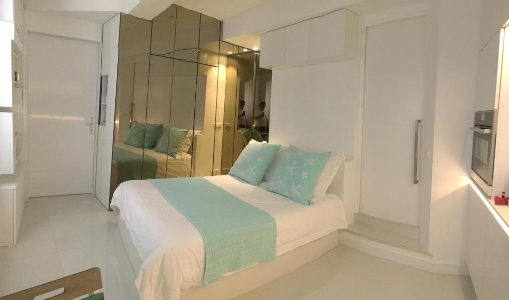 圣特罗佩Stone studio的白色卧室配有蓝色枕头的床