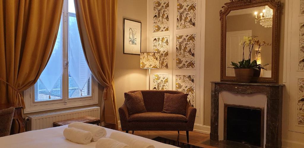 BléréLA MAISON LEONARD的一间卧室配有一张床、一把椅子和镜子