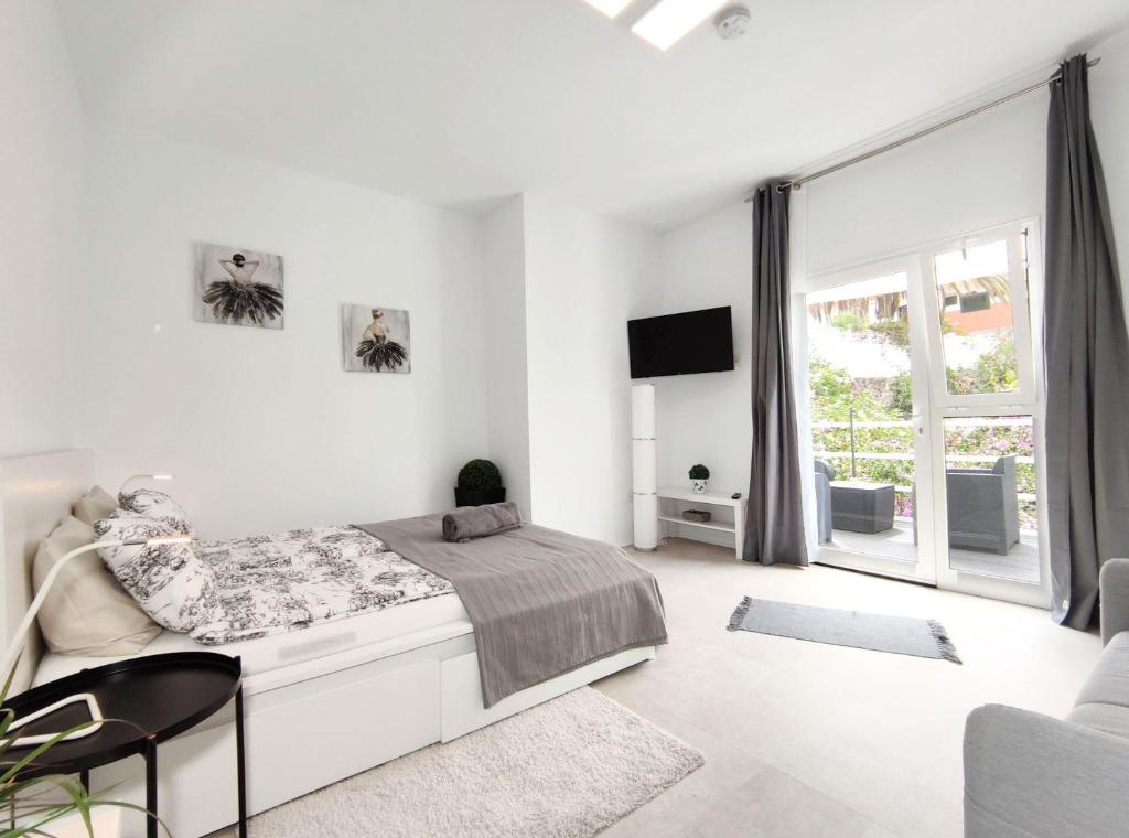 拉克鲁斯Fantastico的白色的卧室设有床和大窗户