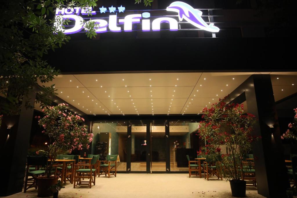 马马亚Hotel Delfin的大楼前设有桌椅的餐厅
