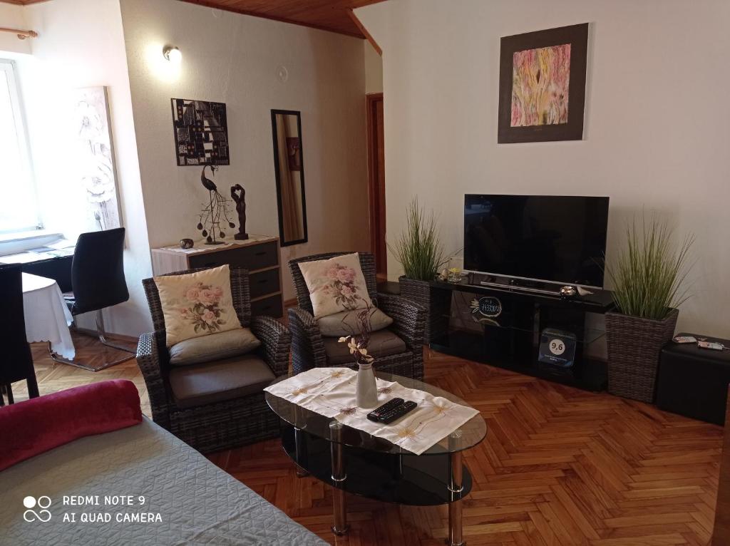 罗维尼Apartment Piazza Antica的客厅配有桌子和电视
