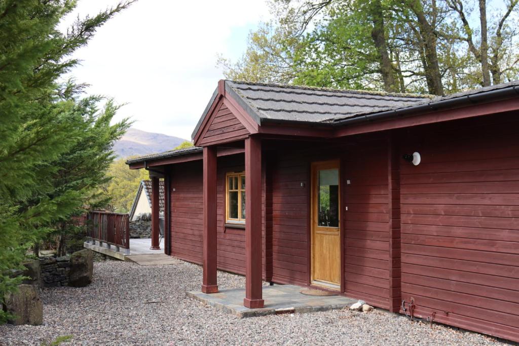 格拉斯哥Lodge 37 Rowardennan, Loch Lomond的红色小屋,设有门廊和门