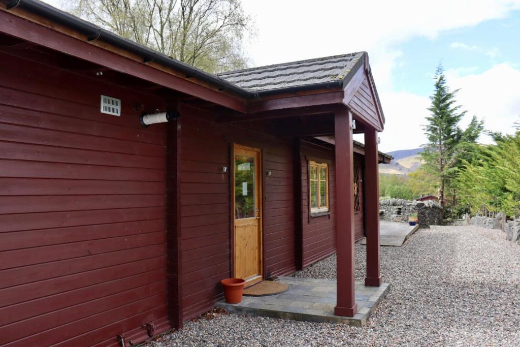 格拉斯哥Lodge 38 Rowardennan , Loch Lomond的红色的建筑,设有门廊