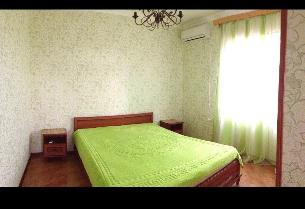 加格拉Гостевой дом的一间卧室设有一张绿色的床和一个窗户。