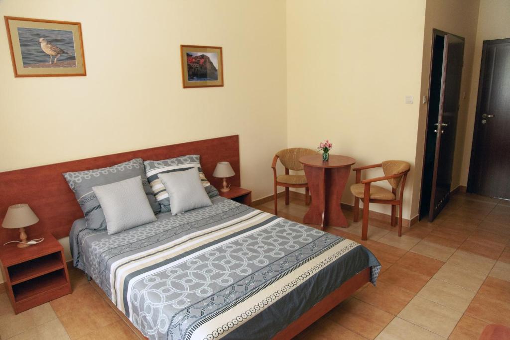 达洛科达罗科假日旅馆的卧室配有一张床和一张桌子及椅子