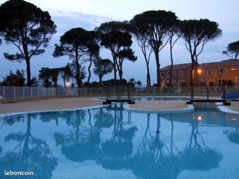卡勒维松Maison résidence entre Terre et Mer的一座树木环绕的大型游泳池