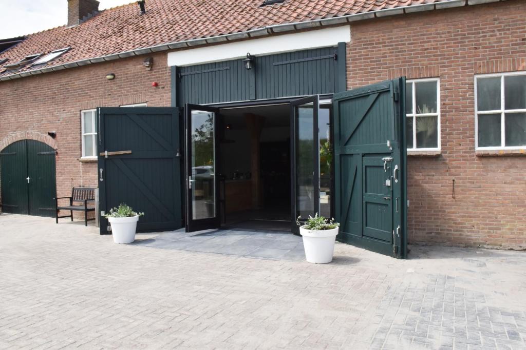 坎珀兰ZeeLand & Meer的砖砌成盆栽的砖砌建筑的敞开的门