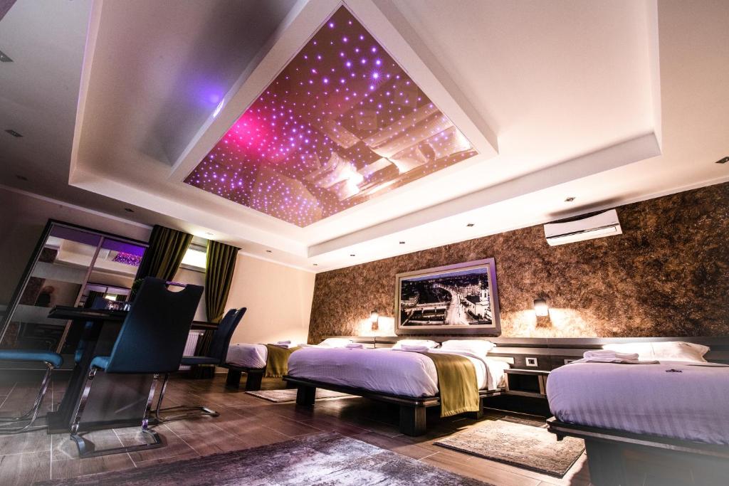奥拉迪亚Hotel Novotheos的一间卧室设有两张床和星空天花板