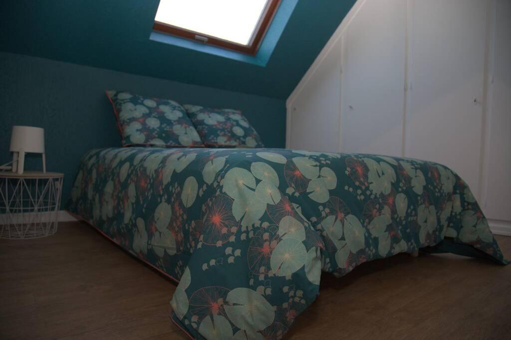 EckwersheimGîte alsacien的一间卧室配有一张带鲜花毯子的床和窗户。