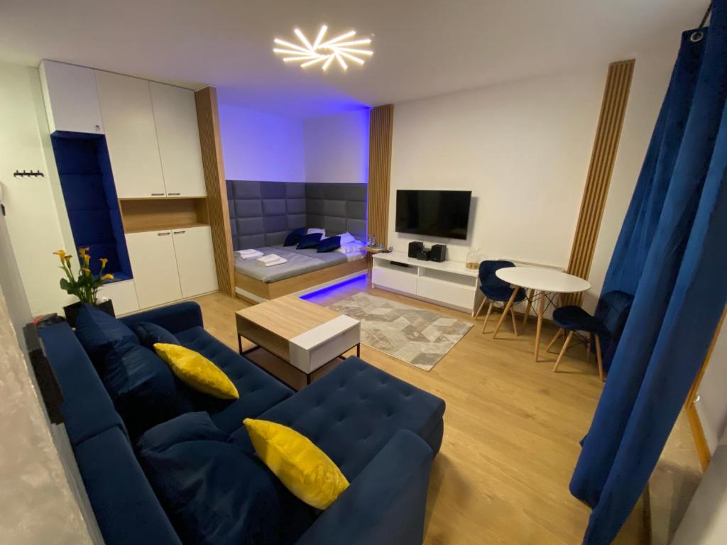 华沙Secret Apartments Chełmska的客厅配有蓝色的沙发和桌子