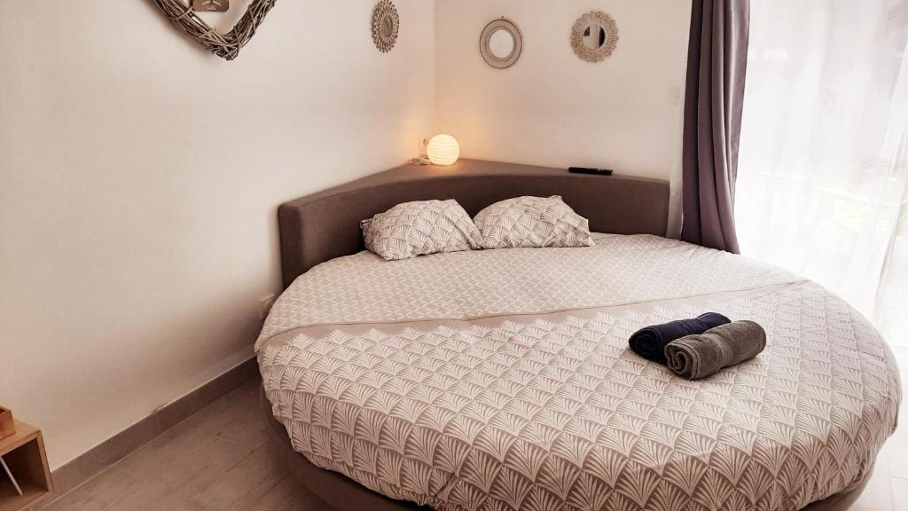 尼姆Allegria Nimes Chambre Deluxe Spa的一张带两个枕头的床和一顶帽子