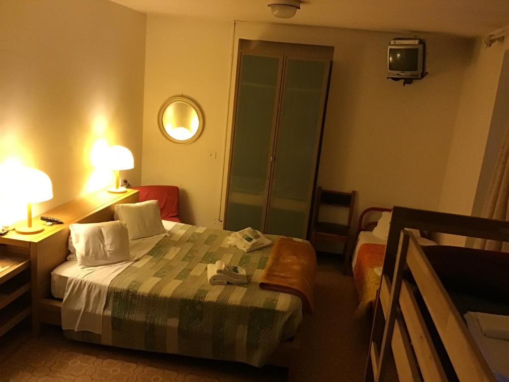 贝拉吉奥OSTELLO MIRABEAU的酒店客房,配有床和镜子