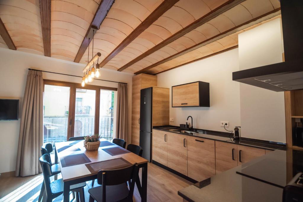 Alós de BalaguerCal Negret Rural Apartments的厨房以及带桌椅的用餐室。