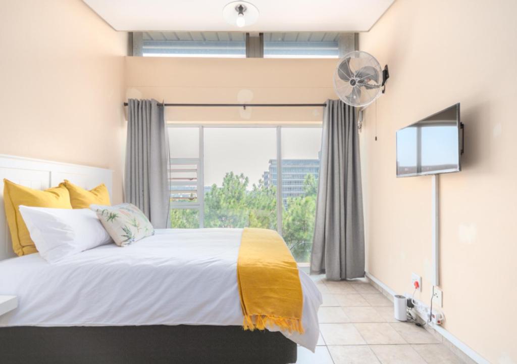 比勒陀利亚Leas Furnished Apartments - Capital Hill的一间卧室设有一张床和一个大窗户