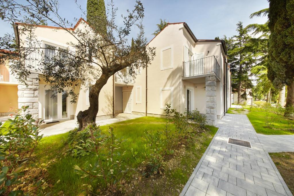 安卡兰Olive Family Suites - Hotel & Resort Adria Ankaran的享有带走道的白色房屋的外部景色