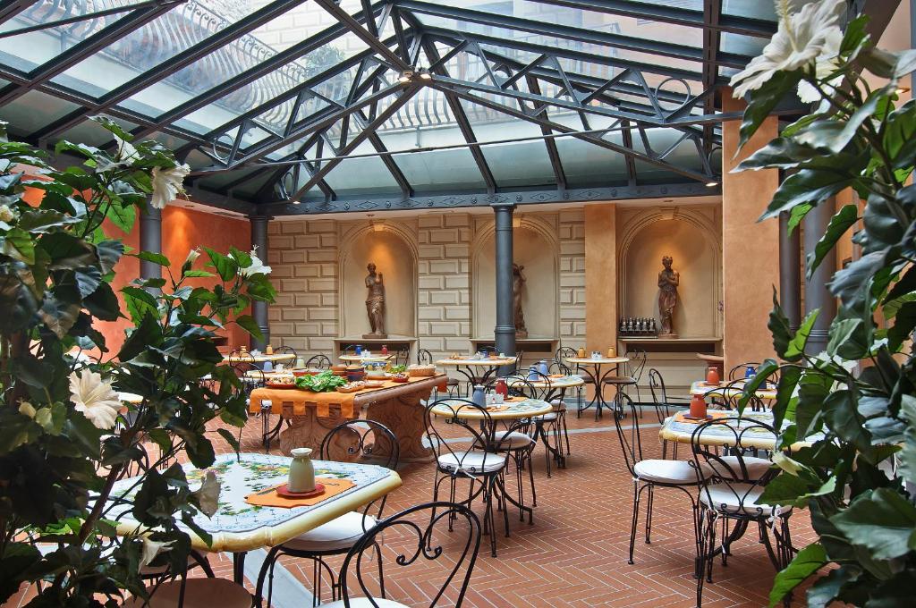 佛罗伦萨阿尔巴宫殿酒店的大楼内带桌椅的天井