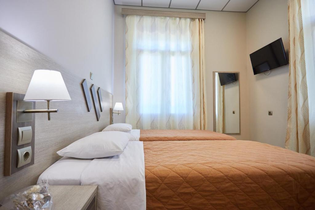 希俄斯Amalia City Rooms的酒店客房设有两张床和窗户。