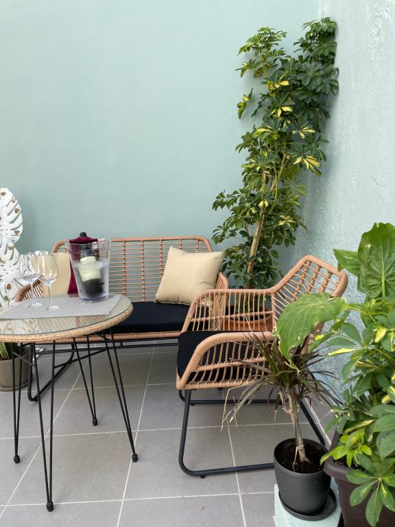 罗德镇Melenia Suites的阳台设有长凳、桌子和植物