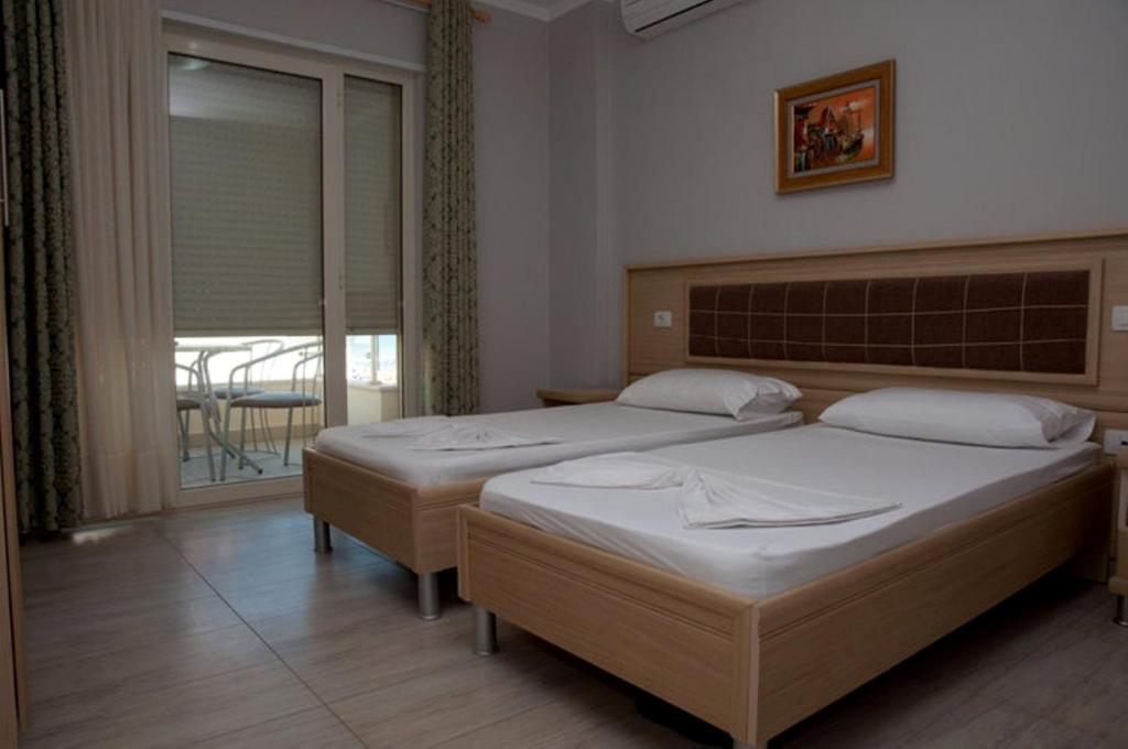 都拉斯Hotel Vila Lule的一间带两张床的卧室和一个带桌子的阳台