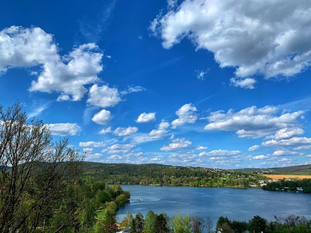布尔诺Penzion Kozí Horka u Brněnské přehrady的享有蓝色天空和云的河流美景