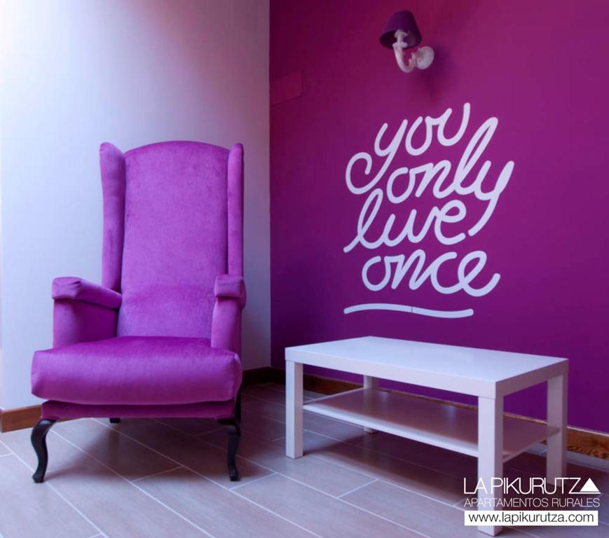 BernedoApartamentos Rurales La Pikurutza的客房内的紫色椅子和桌子