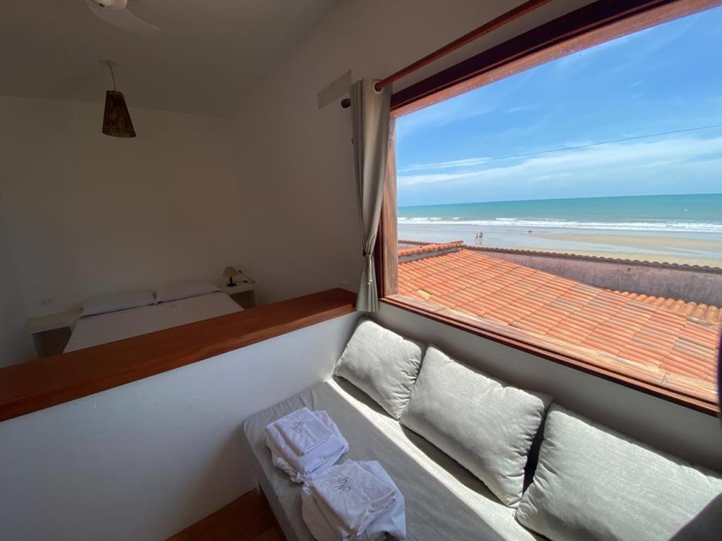 瓜吉鲁Navegantes Nascente的客房设有沙发和享有海滩景致的窗户。