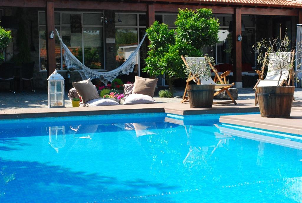 拉梅戈卡萨乐洛基代索勒酒店的一座带椅子和吊床的游泳池位于大楼旁