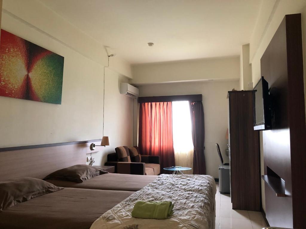 玛琅Apartemen Malang的酒店客房,配有两张床和椅子