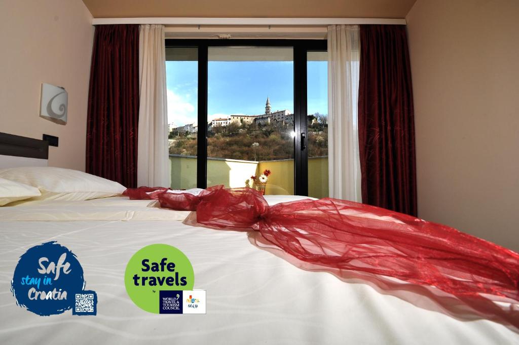 布泽特丰塔纳酒店的一张床上的红色毯子,窗户