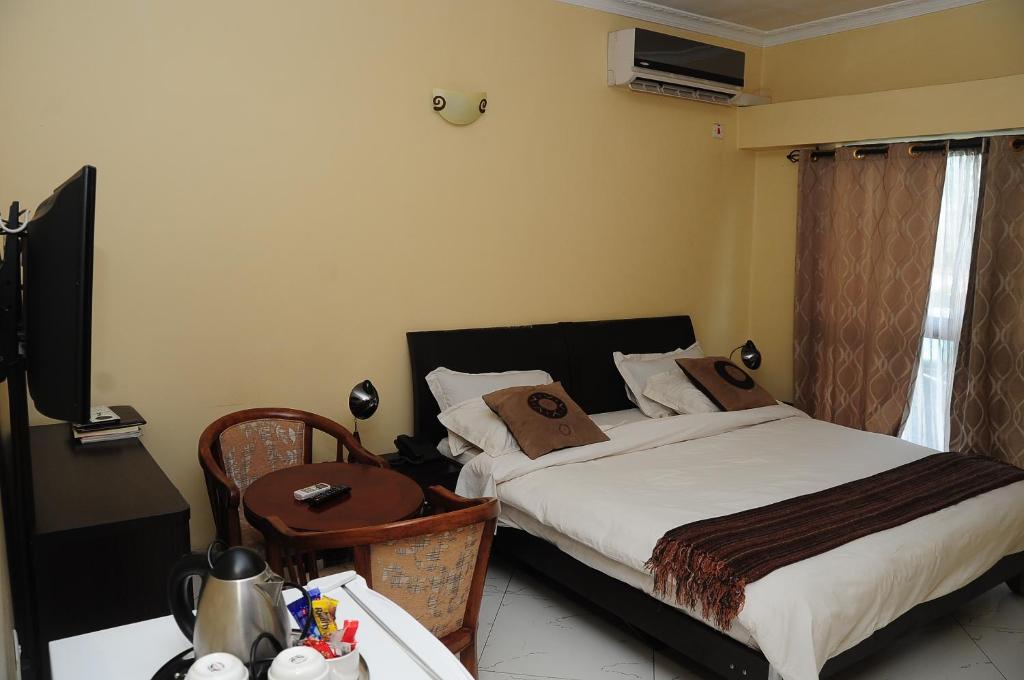 KitweRoad view Park Hotel的一间卧室配有一张床和一张书桌及电视