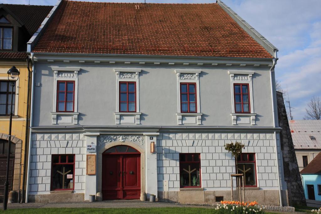 新比斯特日采Apartmány PAPÍK的白色的房子,有红色的门和棕色的屋顶