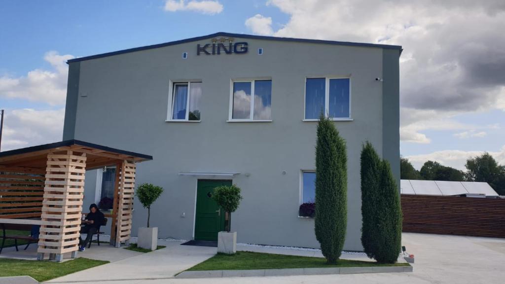 波莫瑞地区德拉夫斯科Guest Inn KING的白色的建筑,上面有国王标志