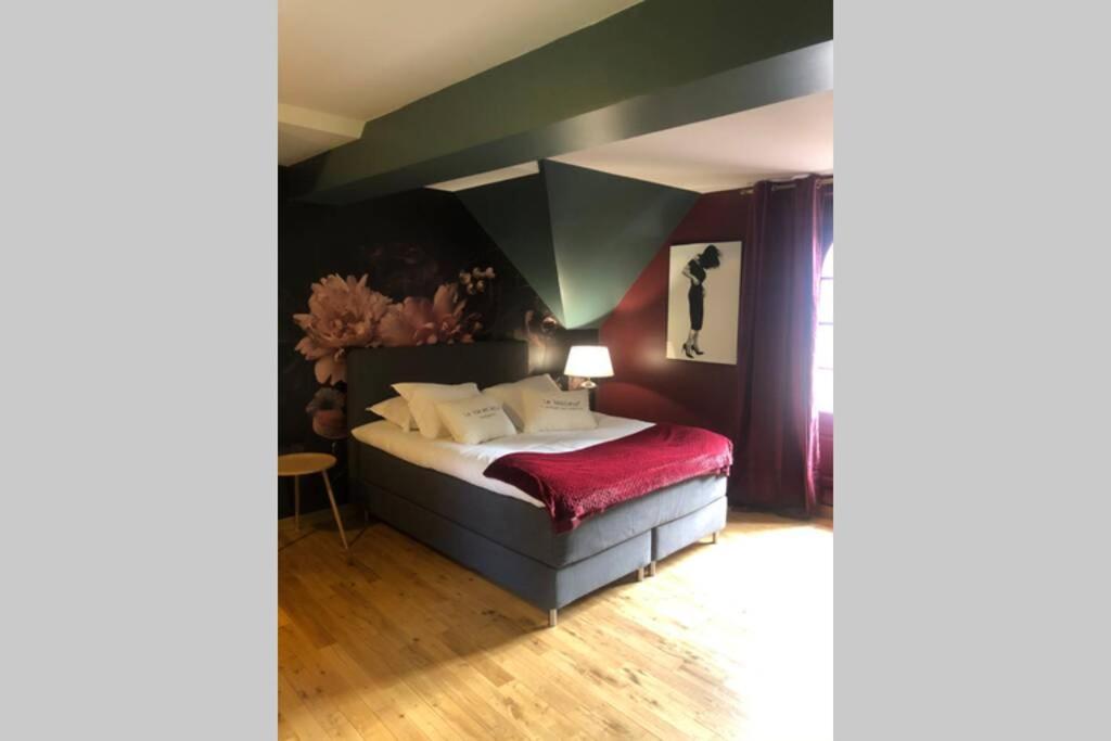 GaucielL’annexe du Manoir的一间卧室配有一张带红色毯子的床