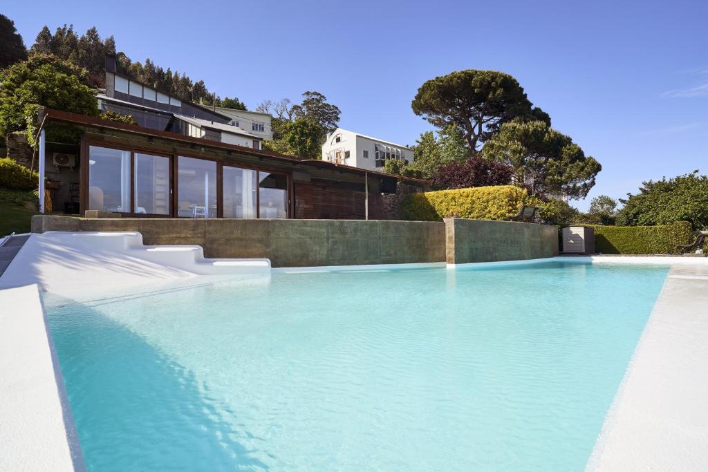 费罗尔Apartamento con piscina y excelentes vistas的一座房子前面的蓝色海水游泳池