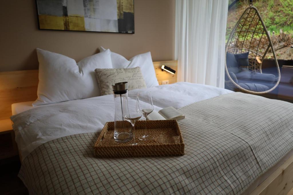 玛丽亚阿尔姆Appartement mit Balkon und Hallenbad的一张带托盘的床上,上面放着两杯眼镜