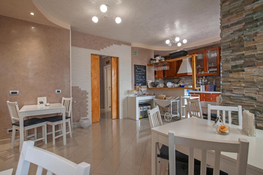 罗马Rogiual的厨房以及带白色桌椅的用餐室。
