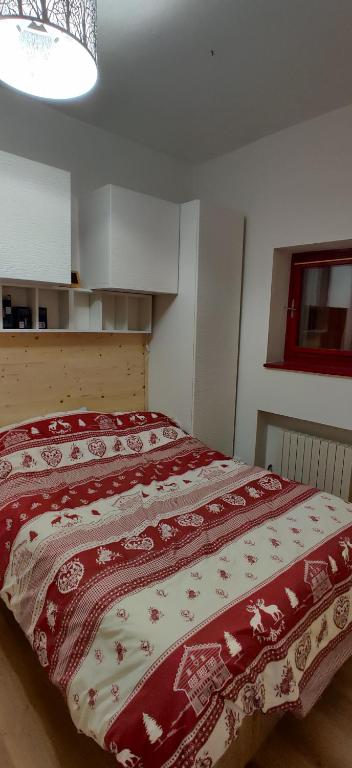 阿贝托内La casetta di Viola的一间卧室配有一张带红色和白色棉被的床