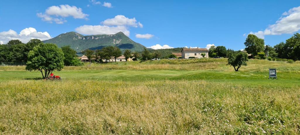 迪涅莱班Residence T2 du Golf de Digne的享有以山脉为背景的高尔夫球场的景致