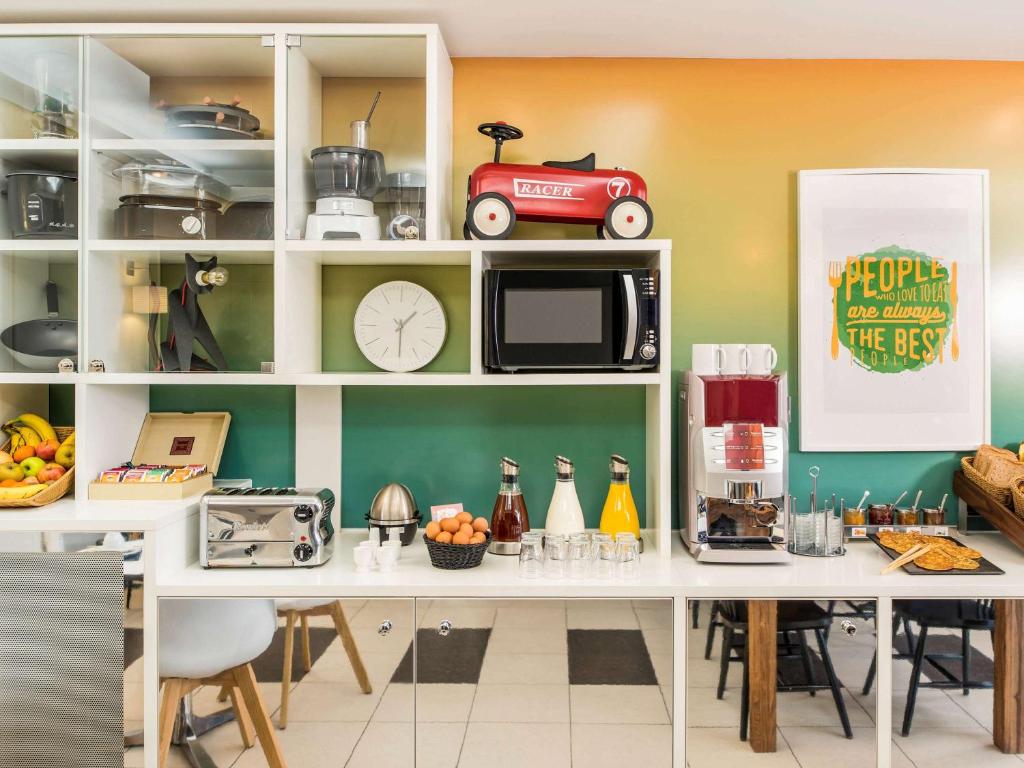 旺夫巴黎旺夫爱达格公寓式酒店 - 波特德夏特林的厨房配有带微波炉的柜台和桌子。