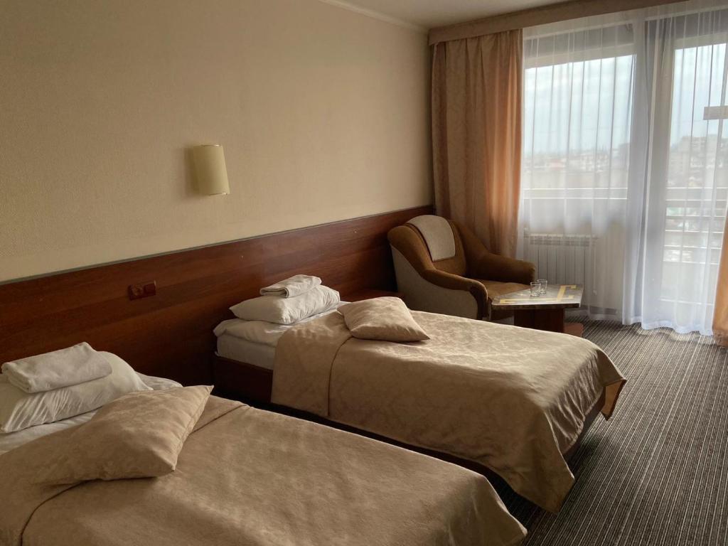 乌日霍罗德Intourist-Zakarpattia Hotel的酒店客房设有两张床和窗户。